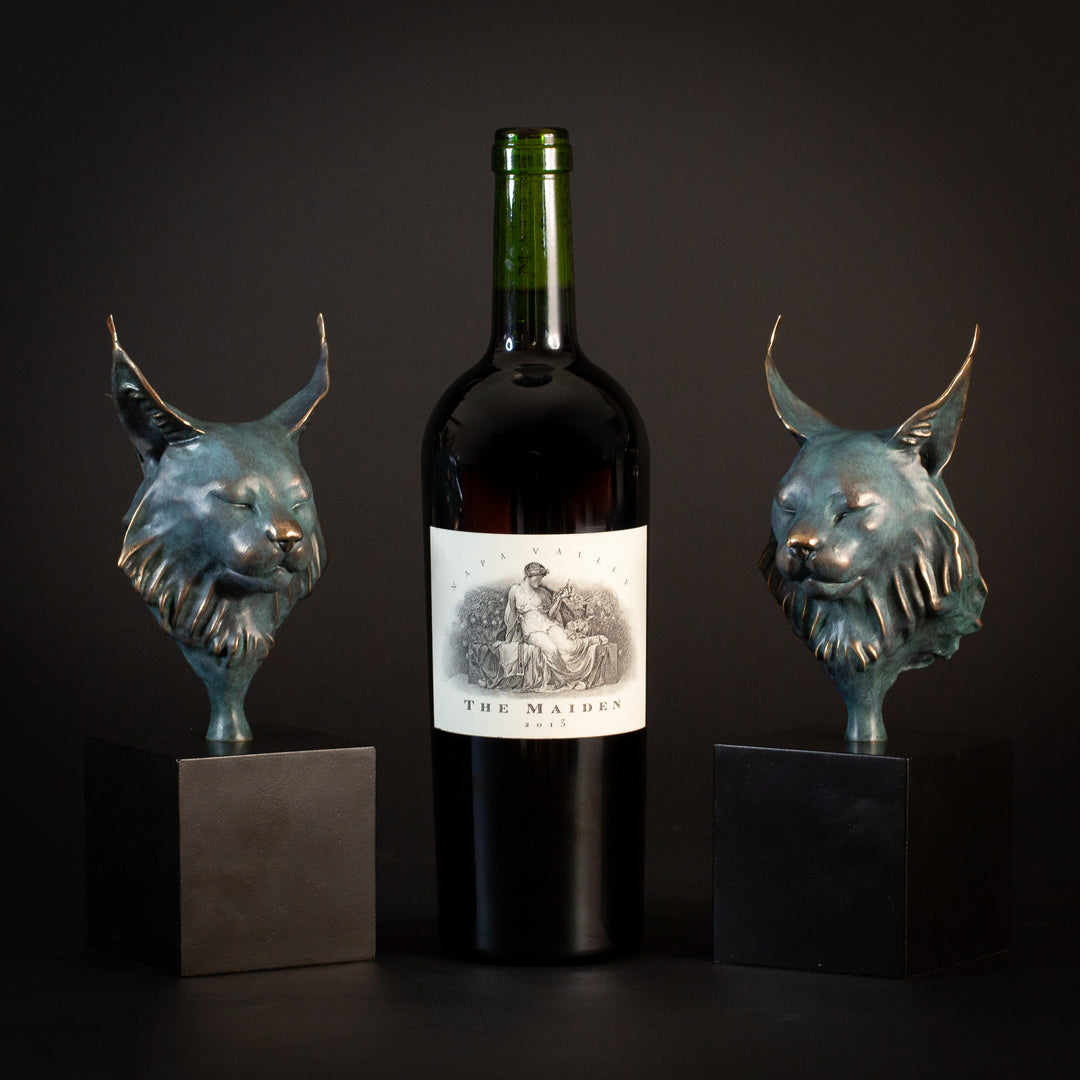 Wee Petra Eurasian Lynx bronze sculpture by Min Reed, miniature lynx head with closed eyes and elegant ear tufts in green verdigris bronze with warm copper highlights, mounted on a small black plinth, contemporary wildlife bronze sculpture