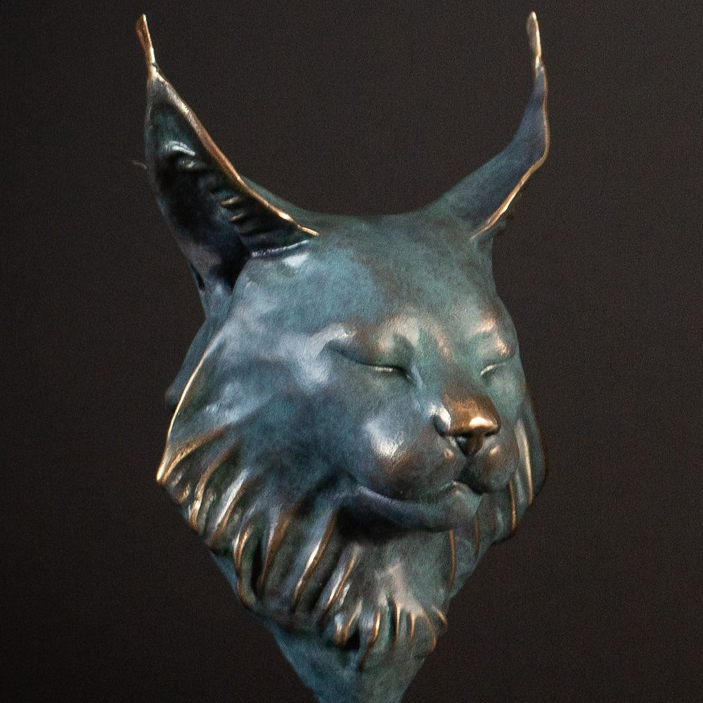 Wee Petra Eurasian Lynx bronze sculpture by Min Reed, miniature lynx head with closed eyes and elegant ear tufts in green verdigris bronze with warm copper highlights, mounted on a small black plinth, contemporary wildlife bronze sculpture