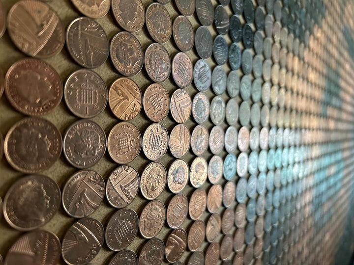 Ed Chapman mosaic portrait of Marilyn Monroe created from 2,301 one penny coins, forming a shimmering likeness through copper, bronze, and dark patina tones, a striking pop culture artwork blending currency and fine art.