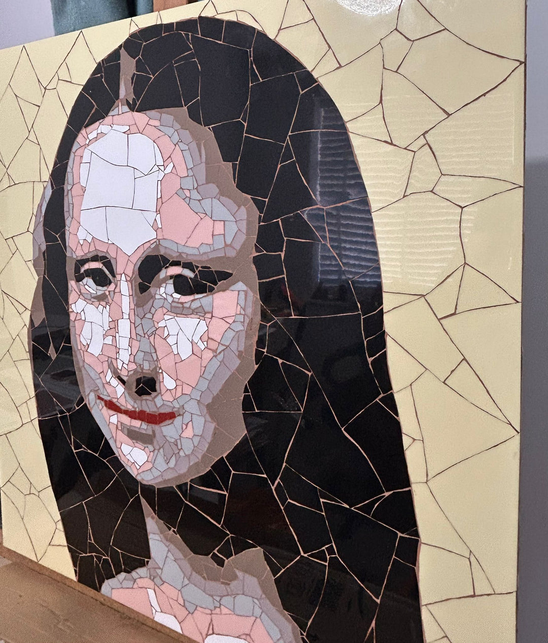 Ed Chapman Mosaic portrait of the Mona Lisa constructed from precisely cut ceramic tiles, with angular fragments forming the face, hair and clothing through subtle tonal shifts, set against a bold yellow background and creating a structured, tactile surface with visible tile joins and rhythmic patterning.