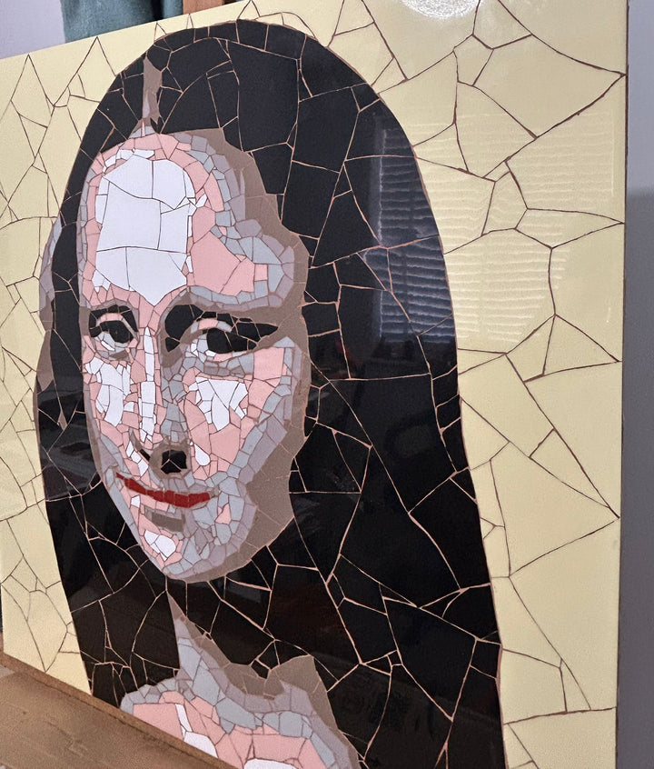 Ed Chapman Mosaic portrait of the Mona Lisa constructed from precisely cut ceramic tiles, with angular fragments forming the face, hair and clothing through subtle tonal shifts, set against a bold yellow background and creating a structured, tactile surface with visible tile joins and rhythmic patterning.