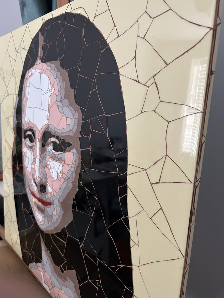 Ed Chapman Mosaic portrait of the Mona Lisa constructed from precisely cut ceramic tiles, with angular fragments forming the face, hair and clothing through subtle tonal shifts, set against a bold yellow background and creating a structured, tactile surface with visible tile joins and rhythmic patterning.