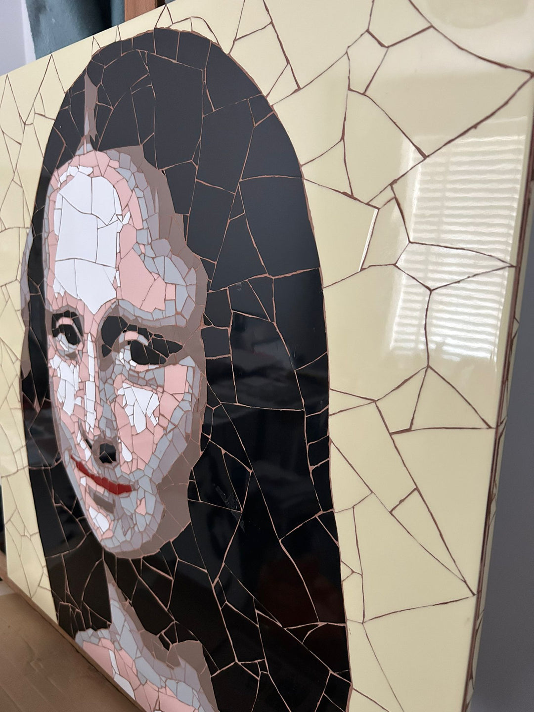 Ed Chapman Mosaic portrait of the Mona Lisa constructed from precisely cut ceramic tiles, with angular fragments forming the face, hair and clothing through subtle tonal shifts, set against a bold yellow background and creating a structured, tactile surface with visible tile joins and rhythmic patterning.