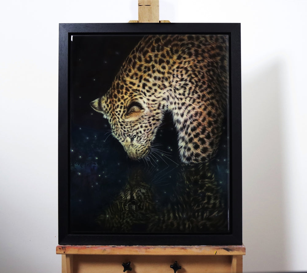 A leopard gazes into a star-speckled water reflection at night, its golden fur glowing against the dark background.