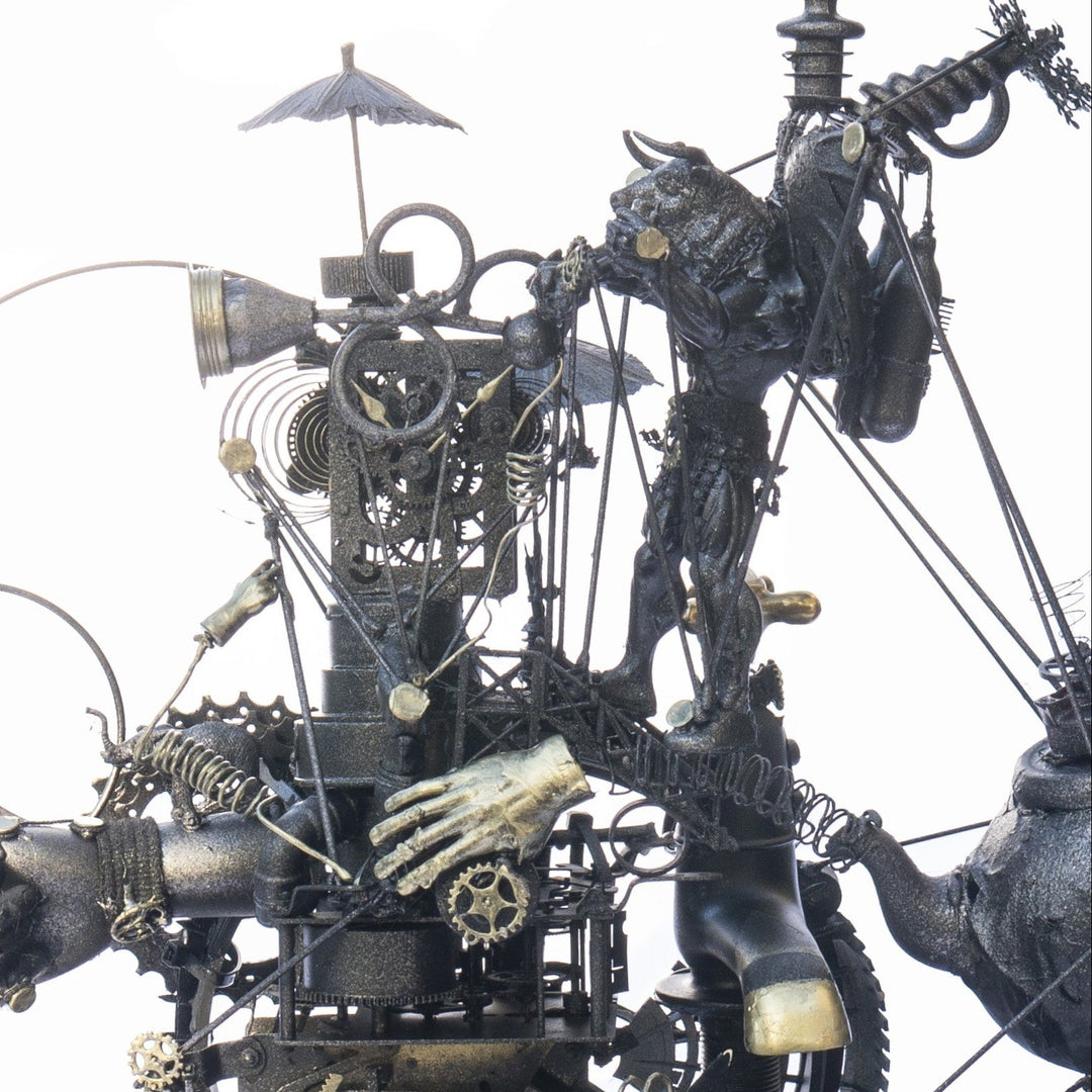 Steampunk assemblage sculpture built from recycled objects including broken toys, china fragments, metal gears, pipes, teapot, figurative limbs and mechanical components, all finished with a dark bronze patina inside a circular frame.