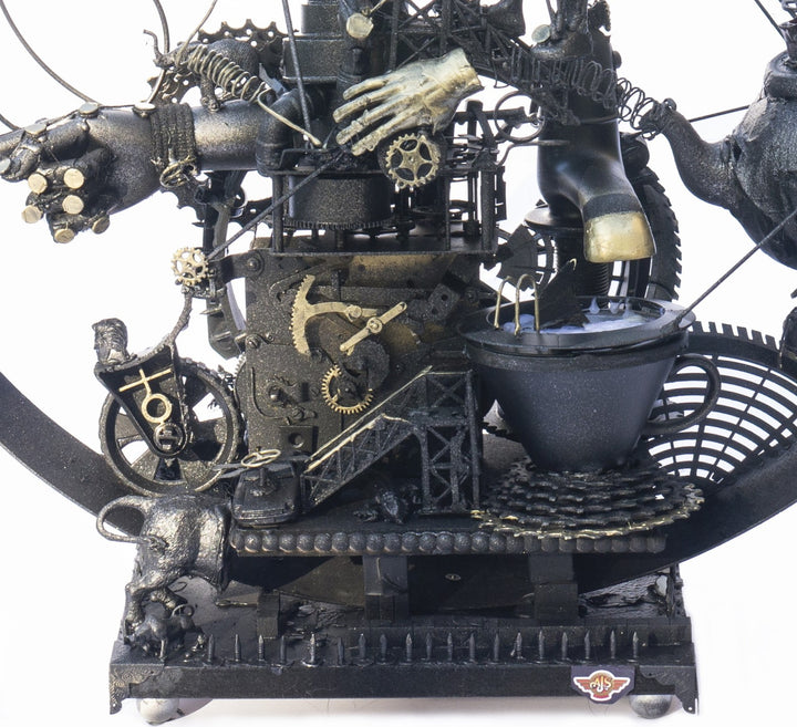 Steampunk assemblage sculpture built from recycled objects including broken toys, china fragments, metal gears, pipes, teapot, figurative limbs and mechanical components, all finished with a dark bronze patina inside a circular frame.