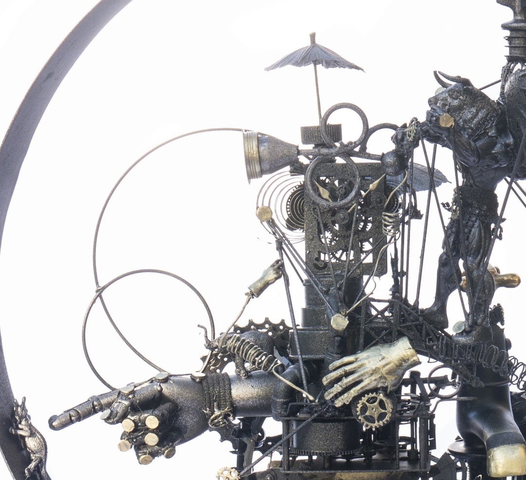 Steampunk assemblage sculpture built from recycled objects including broken toys, china fragments, metal gears, pipes, teapot, figurative limbs and mechanical components, all finished with a dark bronze patina inside a circular frame.