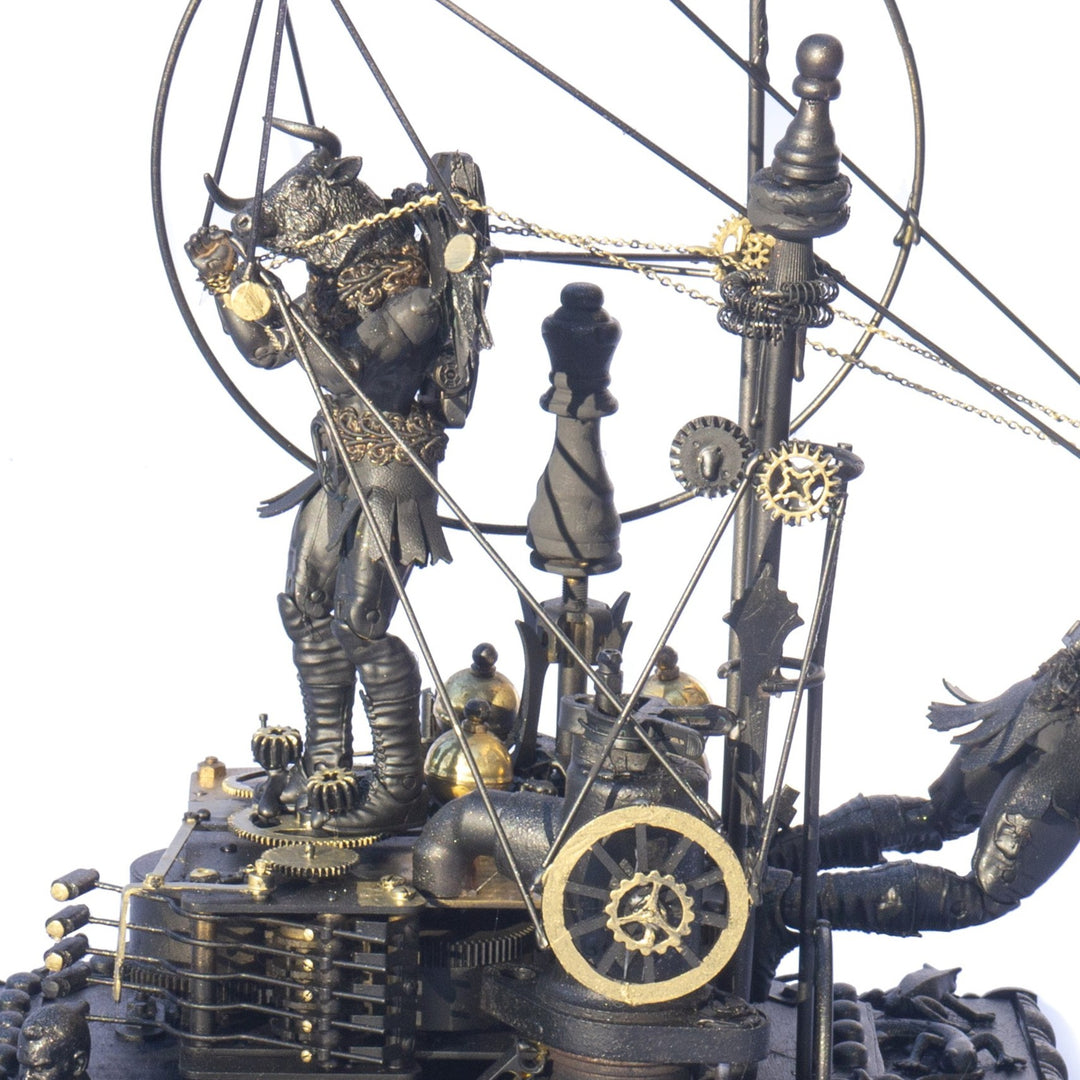 A steampunk sculpture featuring winged minotaur figures assembled from broken toys, brass clock parts, wood offcuts and metal components, all finished in a dark bronze patina. The figures appear in playful motion, including one holding a tennis racket, set on an ornate mechanical base with gears and cogs.