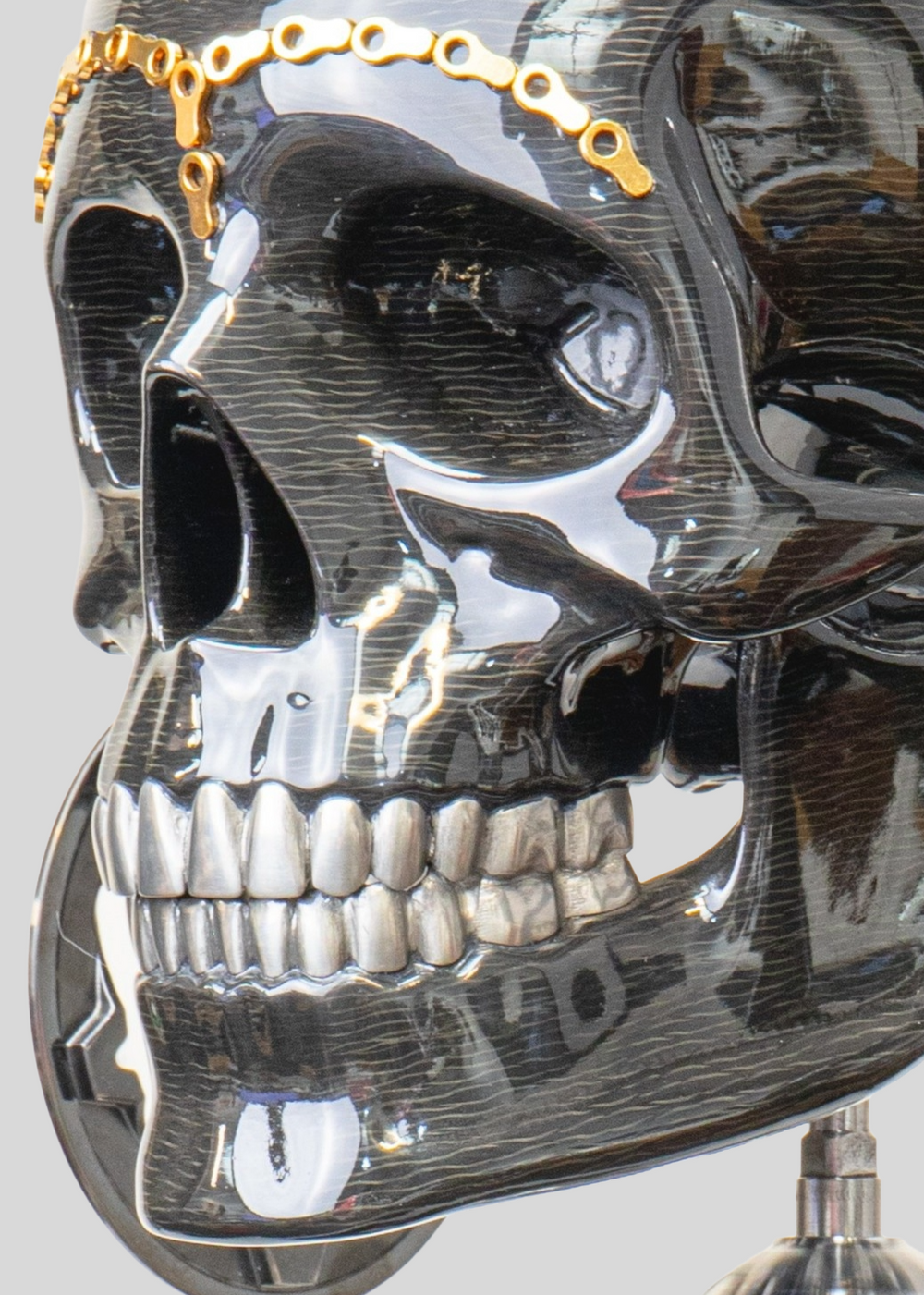 Alastair Gibson CarbonArt45 carbon fibre skull sculpture with high-gloss finish, Formula One components, stainless steel bolt crown detail, gold-plated accents and precision-engineered metal base