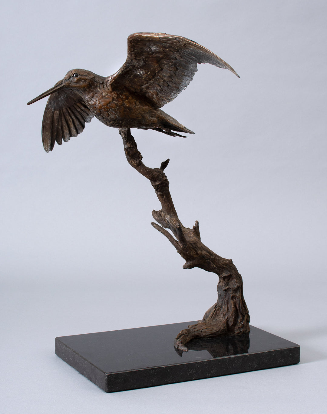 Close-up of a bronze Woodcock sculpture with wings extended in flight, detailed feather texture and elongated beak