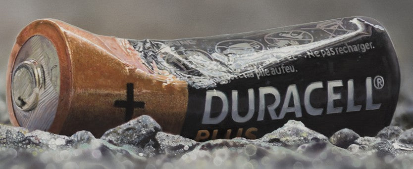 Simon Taylor, YOU LEFT ME POWERLESS (Original), oil and acrylic on aluminium, 25 x 60cm – photorealist painting of a discarded Duracell battery lying on grey gravel, rendered with hyperreal precision.