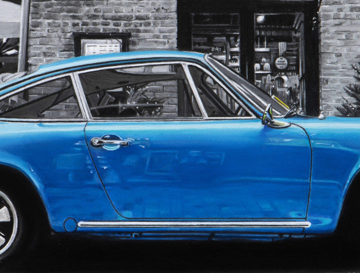 Limited edition giclée print by Ray West depicting a blue 1971 Porsche 911 parked on London’s Southbank, rendered in hyper-realistic pastel detail with the car set against a finely detailed monochrome urban backdrop, printed on archival quality fine art paper.