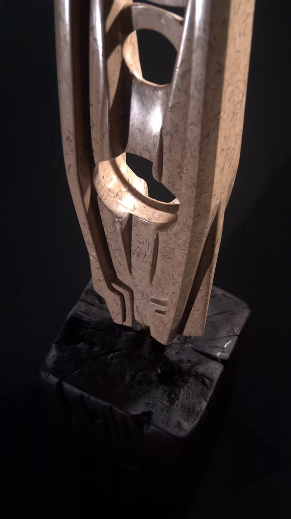 A tall abstract stone sculpture with two inward-facing vertical spires joined at the base, carved in contrasting smooth and textured Purbeck stone, mounted on a dark granite base.