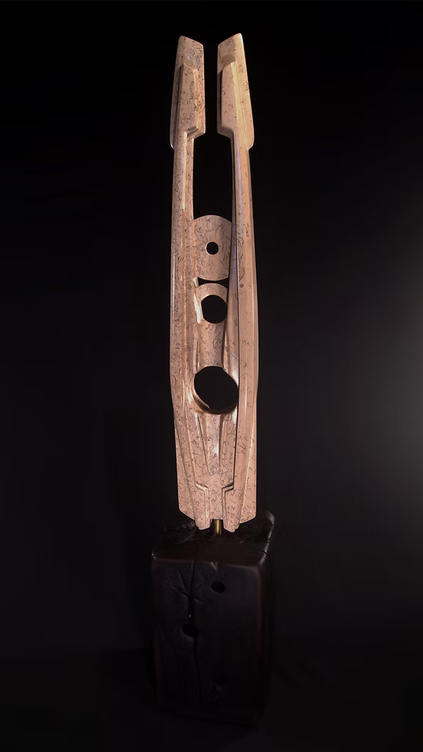 A tall abstract stone sculpture with two inward-facing vertical spires joined at the base, carved in contrasting smooth and textured Purbeck stone, mounted on a dark granite base.