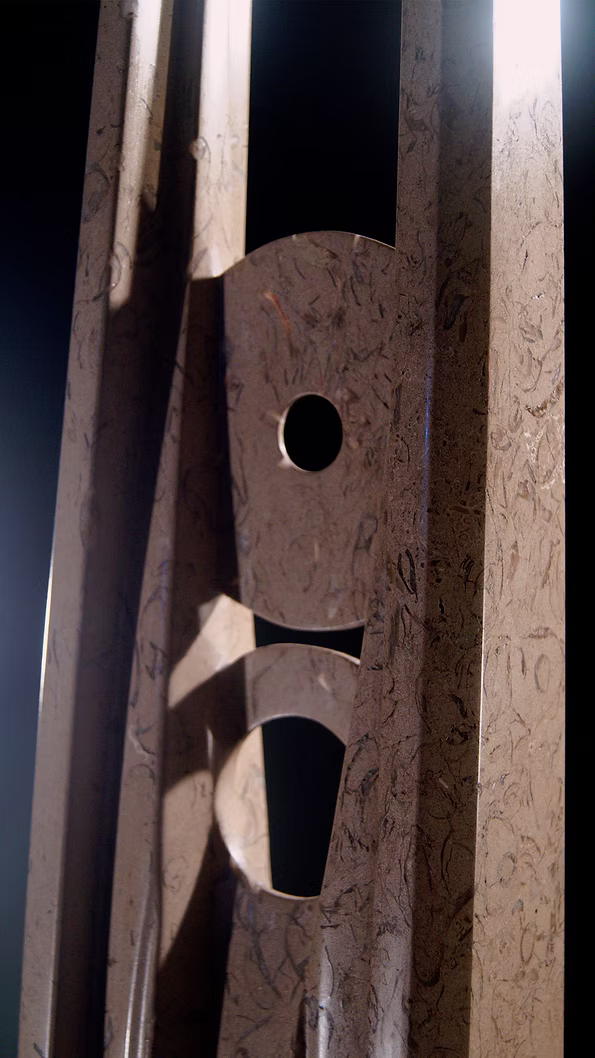 A tall abstract stone sculpture with two inward-facing vertical spires joined at the base, carved in contrasting smooth and textured Purbeck stone, mounted on a dark granite base.
