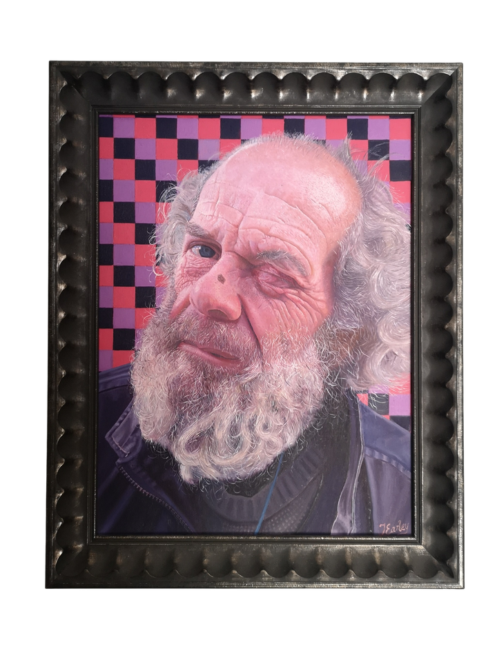 Anthony by James Earley — a hyperrealist oil portrait of a bearded man with expressive eyes, set against a vivid checkerboard background of purples, reds, and blacks. Every line, wrinkle, and hair is painted in meticulous detail, capturing the complexity of emotion in his wry expression.