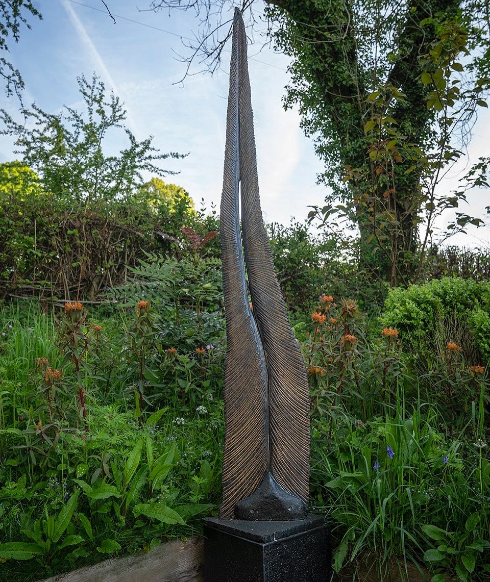 Tall oak sculpture by Glen Farrelly titled Beltane, carved with fine rhythmic grooves and finished using the Yakisugi technique. Charred blackened wood with bronze undertones, symbolising spring, fertility, and renewal.