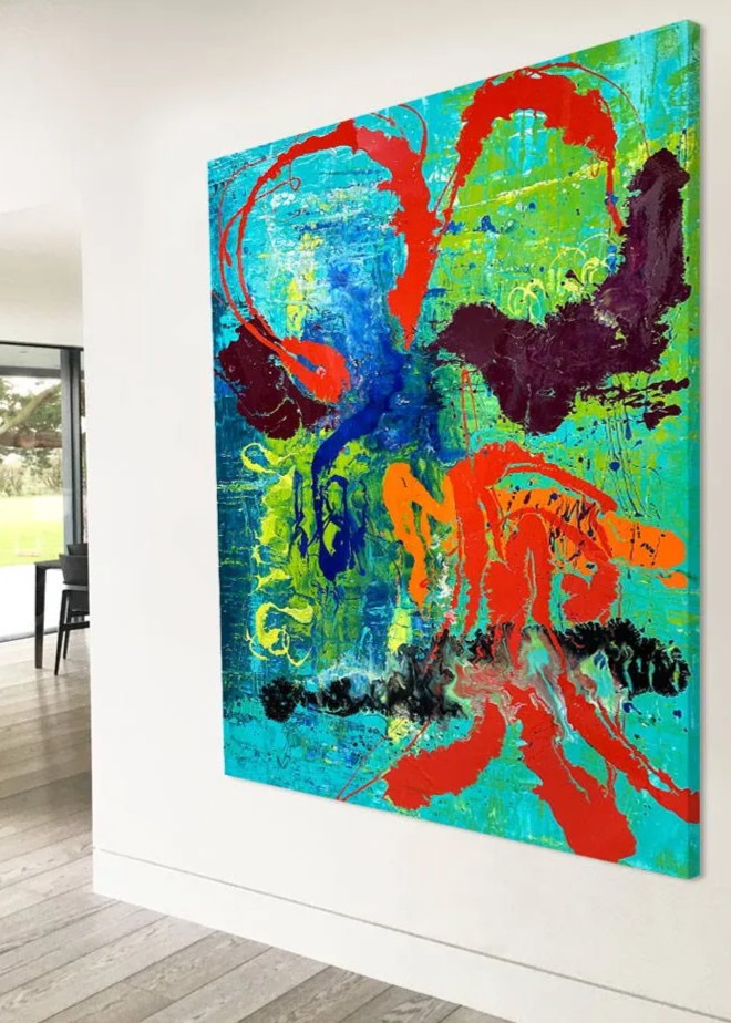 Large abstract painting “Infinite Light” by Swarez — vibrant sweeping strokes of scarlet red, fiery orange and deep burgundy layered over a luminous turquoise and lime green base, with accents of cobalt blue and black. Highly textured enamel surface with bold movement and glossy, light-catching details.