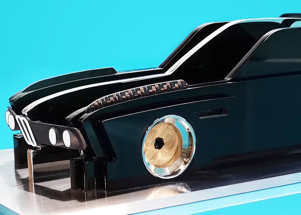 Sculptural model of the 1970s BMW E9 “Batmobile” touring car by Jonny Ambrose — a black, layered acrylic and carbon fibre form with polished aluminium details on a brushed acrylic plinth, capturing its dramatic wings and flared racing silhouette.