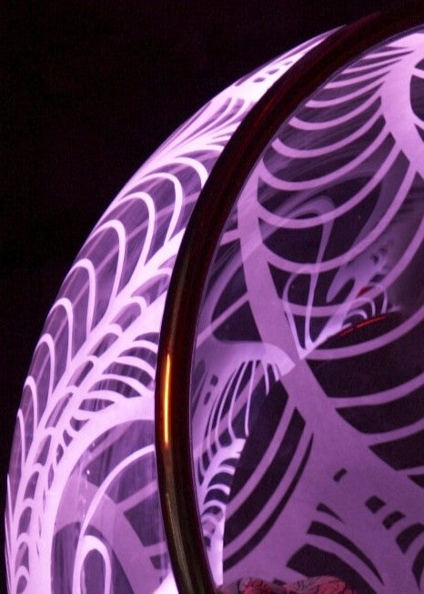 Ben Rousseau, Illuminated Bubble Chair – a limited-edition hanging sphere with engraved acrylic, vibrant pink-purple LED glow, and Mongolian sheepskin cushion featuring INSA’s signature pattern. A cocoon-like statement chair blending art, comfort, and sensory light.