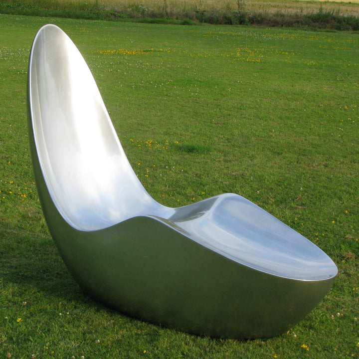 “Caillou Chaise – Metallic Wet Spray” by Ben Rousseau – a sculptural chaise inspired by 1960s grand tourers, hand-shaped in composite with a high-gloss metallic lacquered finish in white, lime, gold, or silver. A fusion of luxury design and form.