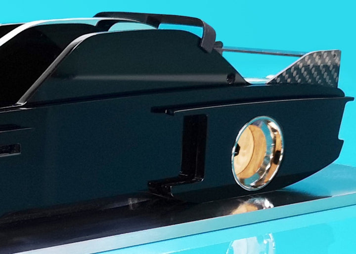 Sculptural model of the 1970s BMW E9 “Batmobile” touring car by Jonny Ambrose — a black, layered acrylic and carbon fibre form with polished aluminium details on a brushed acrylic plinth, capturing its dramatic wings and flared racing silhouette.