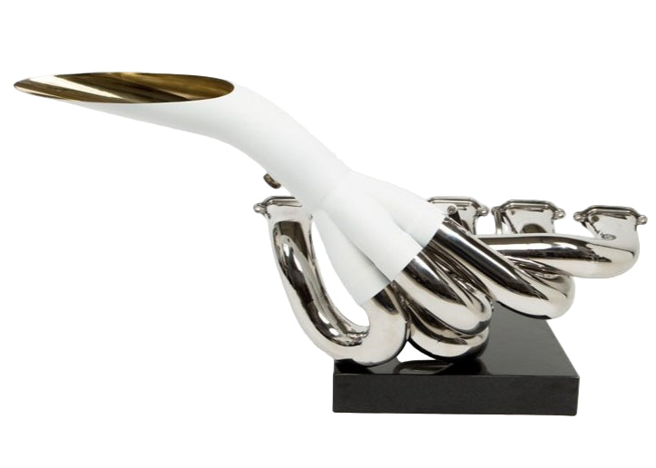 Highly polished sculptural artwork by Mike O’Connor crafted from the authentic race-used exhaust system of Michael Schumacher’s 1995 Benetton B195 Formula One car. The piece features flowing Inconel and stainless-steel pipes with mirror-finished chrome surfaces and 24-karat gold interior detailing, mounted on a sleek stand. A striking one-of-one collector’s piece 