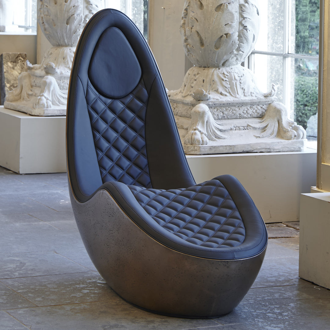 “Caillou Chaise – Leather & Bronze” by Ben Rousseau – a sculptural chaise combining deep navy quilted leather with a liquid bronze base. A handcrafted fusion of strength and sophistication, redefining modern luxury furniture.

