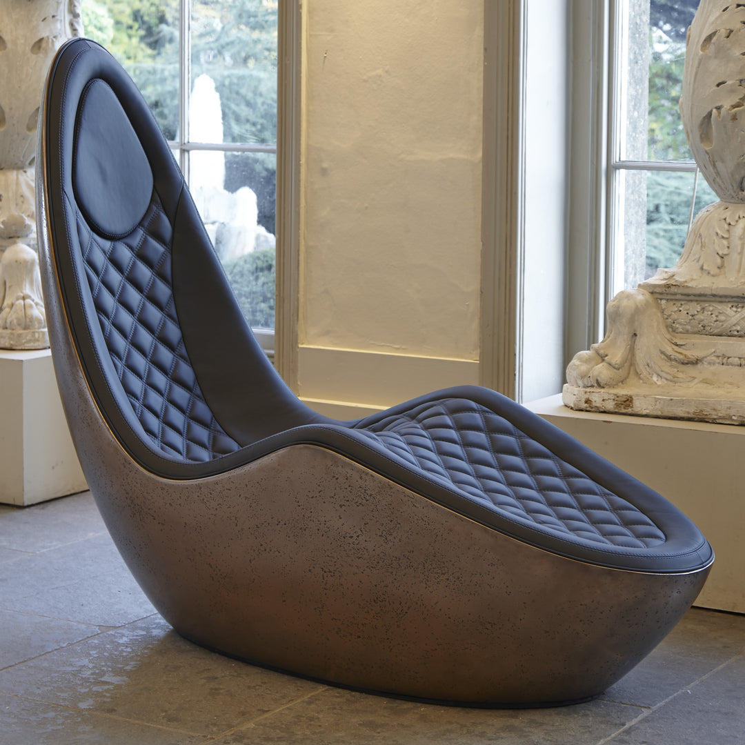 “Caillou Chaise – Leather & Bronze” by Ben Rousseau – a sculptural chaise combining deep navy quilted leather with a liquid bronze base. A handcrafted fusion of strength and sophistication, redefining modern luxury furniture.

