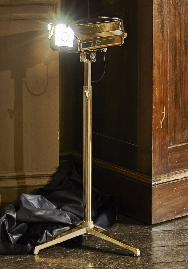 “CCTV Lights – Desk Top” by Ben Rousseau – a sculptural gold-plated LED lamp on a tripod base, reimagining the CCTV camera as a symbol of modern luxury and design. A provocative fusion of technology, art, and illumination.

