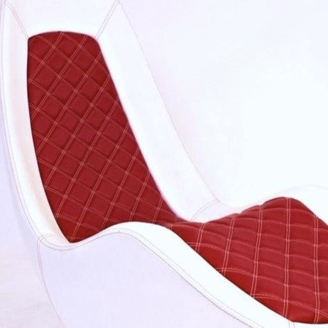 “Caillou Chaise – Leather” by Ben Rousseau – a sculptural chaise in white leather with quilted red stitching, inspired by automotive interiors. Handcrafted in composite with full leather upholstery, merging comfort, craftsmanship, and design.