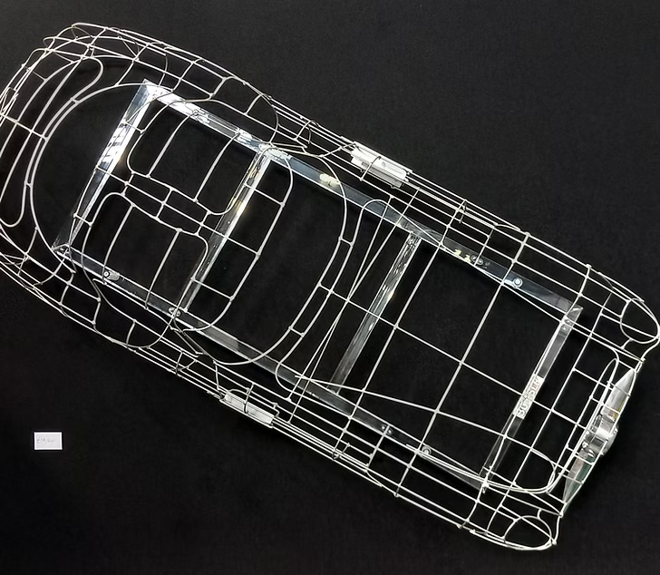 Handcrafted Mercedes-Benz 300 SLR Coupé wire sculpture by Chris Twitchell, inspired by the legendary 1955 Uhlenhaut prototype designed by Friedrich Geiger. Sculpted from precision-formed steel and finished in silver grey DB180, this wall-mounted piece reimagines one of the rarest and most valuable cars ever built — a celebration of German engineering excellence, aerodynamic form, and timeless automotive design.