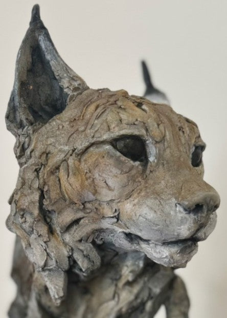 Sculpture of a Eurasian lynx head by Lucy d’Auvergne, cast in slate with raw earth pigments creating warm taupe and grey tones with subtle brown highlights, mounted on a polished granite base.