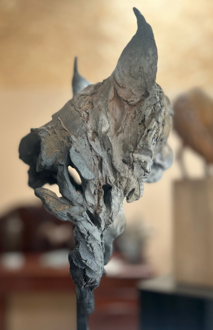 Sculpture of a Eurasian lynx head by Lucy d’Auvergne, cast in slate with raw earth pigments creating warm taupe and grey tones with subtle brown highlights, mounted on a polished granite base.
