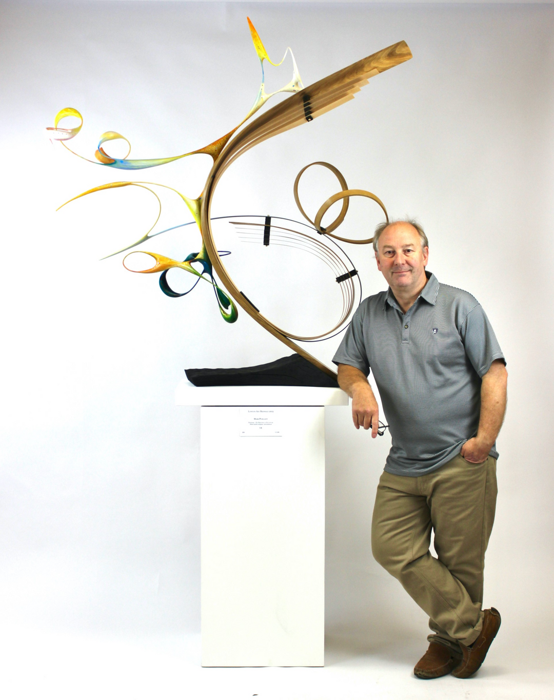 Freedom by Mark Purllant, an award-winning one-off mixed media sculpture in carved and steam-bent English oak with painted sculptural forms, maple veneer, ebony, and brass details, mounted on a scorched oak base with flowing, dynamic curves in yellow, blue, orange, and green.
