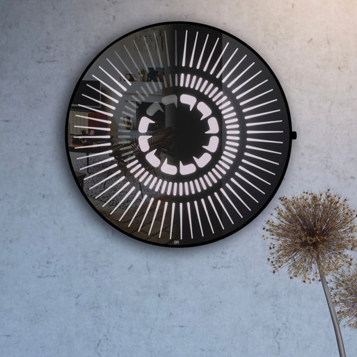 “Tempus Obsidian” by Ben Rousseau – a limited-edition illuminated wall timepiece crafted from grey mirrored glass and brass-tinted aluminium with LEDs. Inspired by obsidian, it radiates calm through subtle light and refined design.

