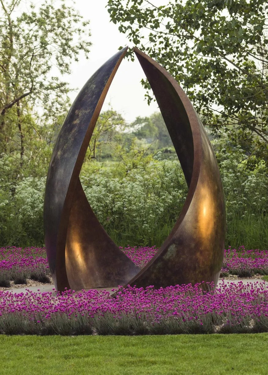 Simon Gudgeon bronze sculpture Embrace featuring monumental abstract curved bronze forms rising upwards and meeting at a central point within a landscaped garden setting.