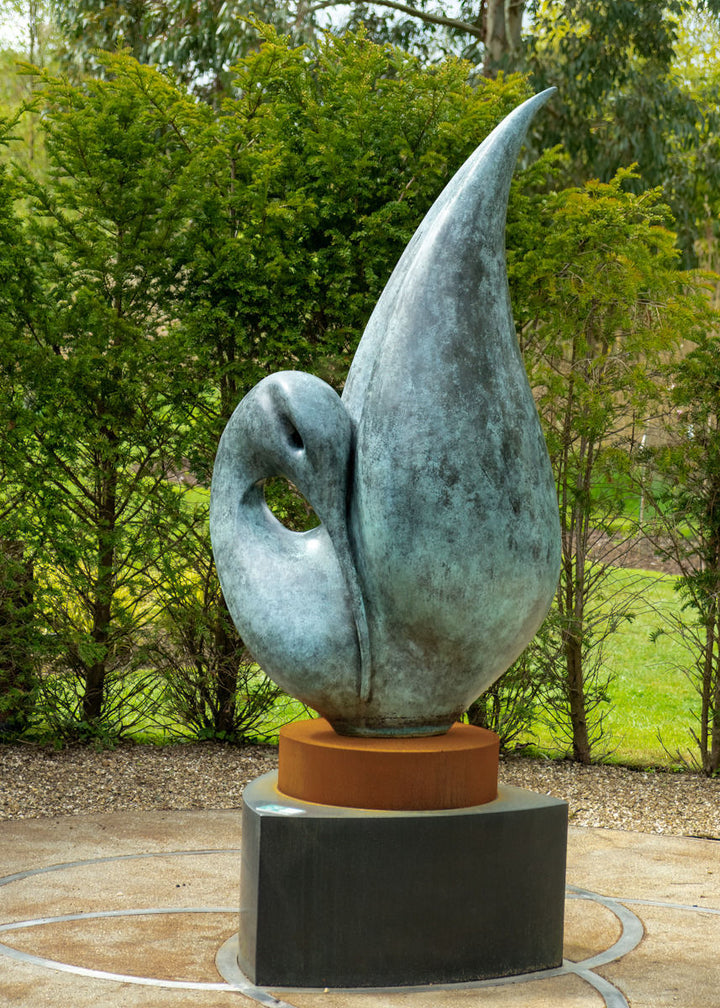 Simon Gudgeon bronze sculpture Reflection featuring an elegant abstract organic form with sweeping curved bronze surfaces displayed within a landscaped outdoor setting.