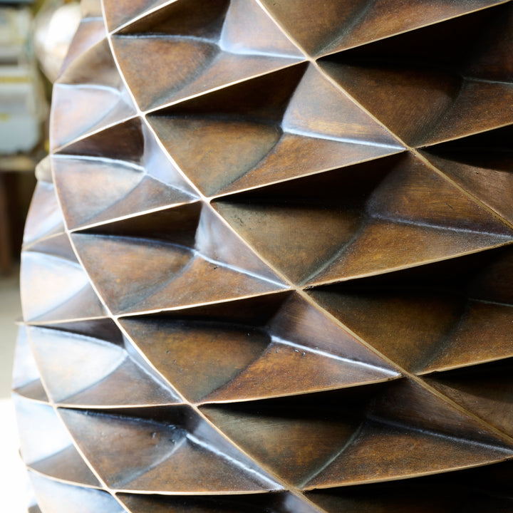 Patinated bronze Pine Cone sculpture by James Parker, with an interlocking spiral surface, geometric scale pattern and tapered organic form inspired by nature and Fibonacci structure.