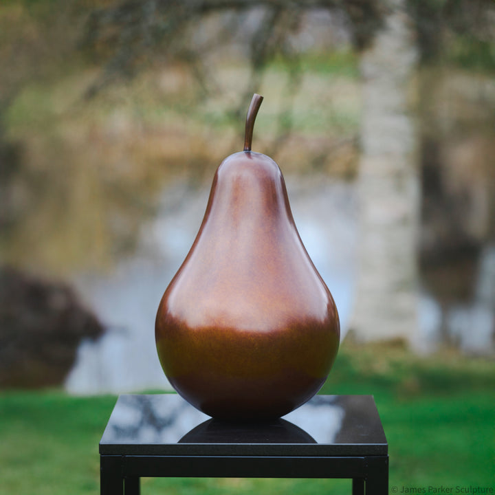 Patinated bronze Pear sculpture by James Parker, with a smooth refined surface, natural stem and generous organic form symbolising abundance, balance and longevity.