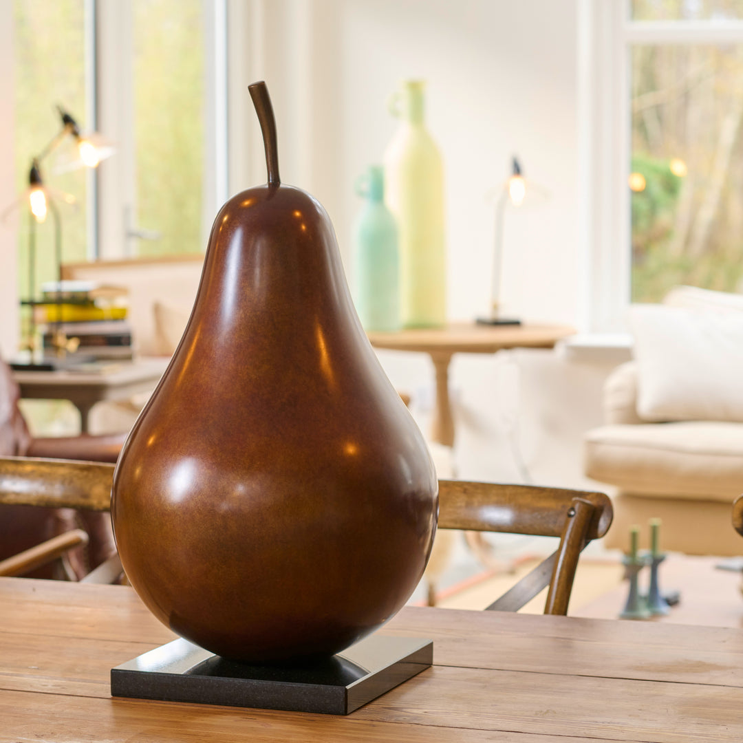Patinated bronze Pear sculpture by James Parker, with a smooth refined surface, natural stem and generous organic form symbolising abundance, balance and longevity.