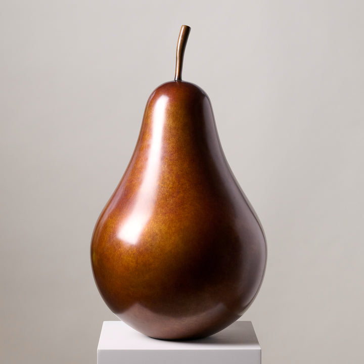 Patinated bronze Pear sculpture by James Parker, with a smooth refined surface, natural stem and generous organic form symbolising abundance, balance and longevity.
