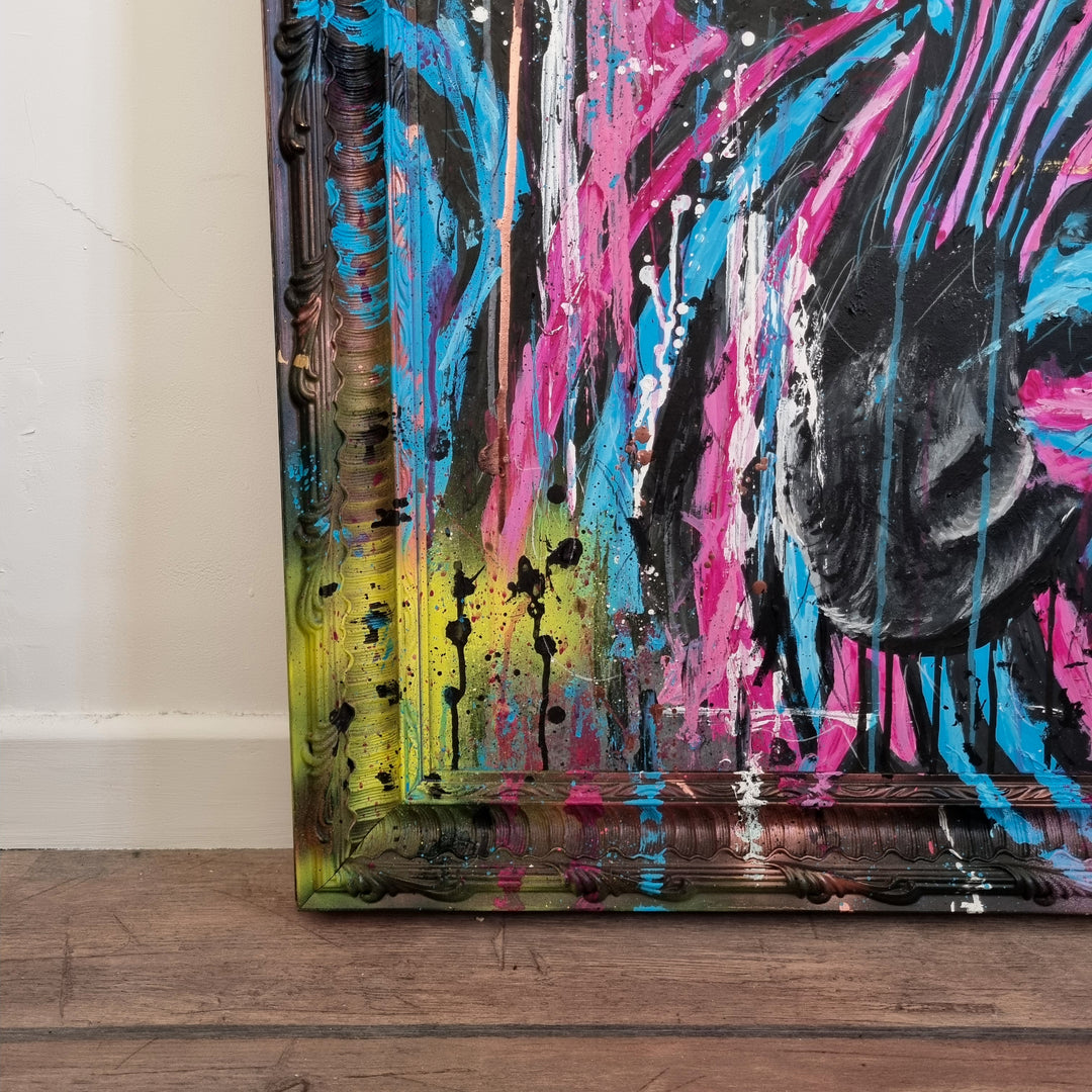 Bold graffiti-style painting of a vibrant zebra titled Equiferus, featuring intense pink, electric blue, black and neon yellow tones, with expressive acrylic and spray paint strokes extending onto a custom-painted ornate frame.