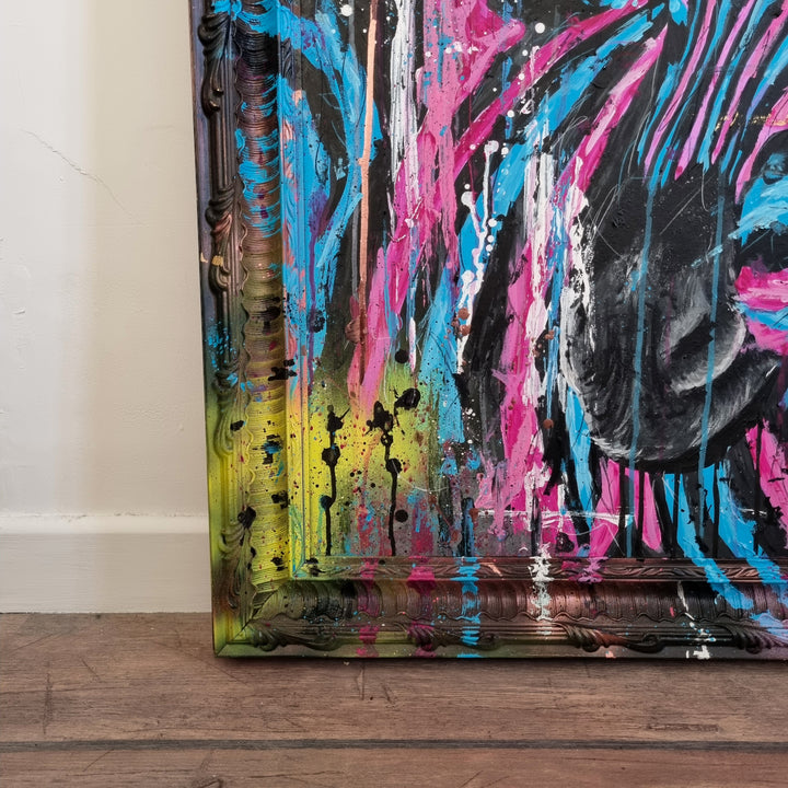 Bold graffiti-style painting of a vibrant zebra titled Equiferus, featuring intense pink, electric blue, black and neon yellow tones, with expressive acrylic and spray paint strokes extending onto a custom-painted ornate frame.