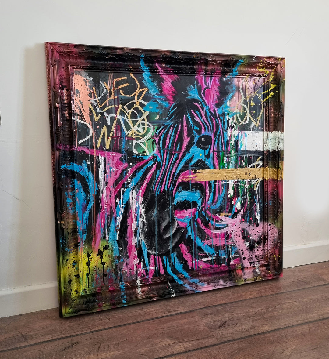 Bold graffiti-style painting of a vibrant zebra titled Equiferus, featuring intense pink, electric blue, black and neon yellow tones, with expressive acrylic and spray paint strokes extending onto a custom-painted ornate frame.