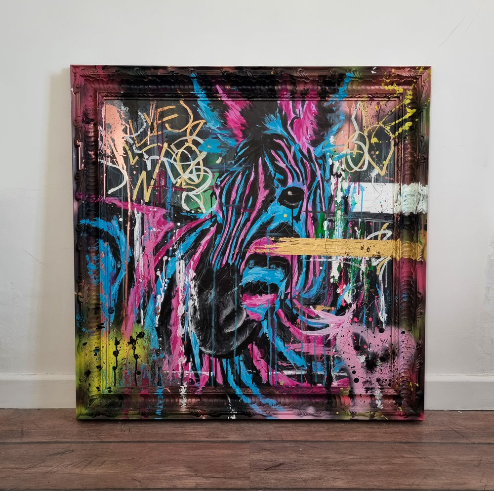 Bold graffiti-style painting of a vibrant zebra titled Equiferus, featuring intense pink, electric blue, black and neon yellow tones, with expressive acrylic and spray paint strokes extending onto a custom-painted ornate frame.