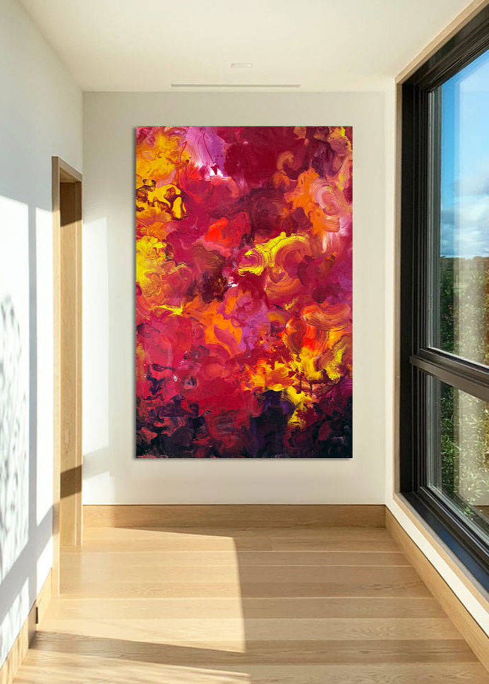 Large abstract painting “Crocosmia” by Swarez — vibrant swirling composition of fiery reds, deep crimson, burnt orange, radiant yellow, and accents of magenta, pink, purple, black, and white. Expressive layered enamel paint with fluid circular motions and botanical-inspired energy.