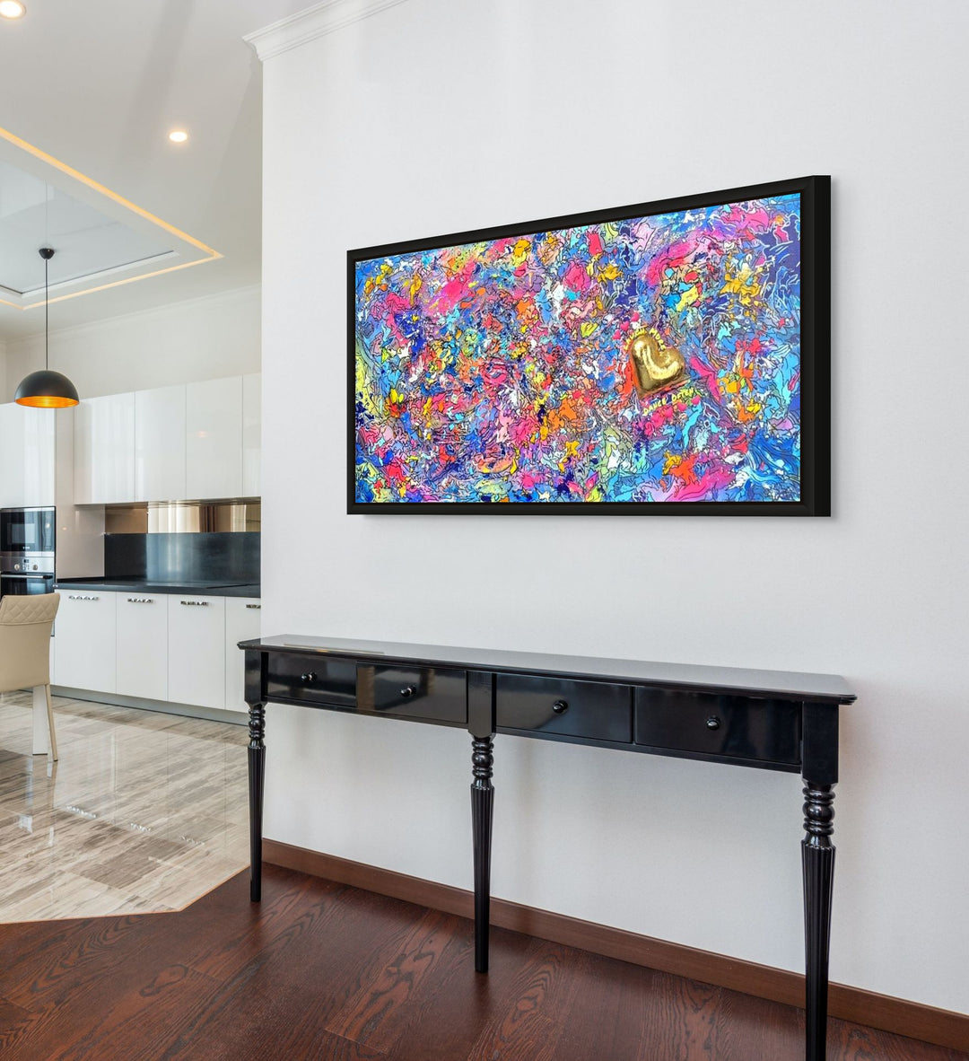 A vibrant abstract mixed-media painting bursting with swirling colours in pink, blue, yellow, orange and purple, with heavy texture and fluid forms. At the right side, a raised gold 3D heart sits prominently with text around it reading “Laugh More, Dance Often”. The artwork has an expressive, energetic surface with layered paint and resin details.