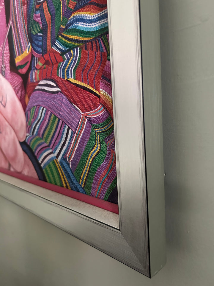 Mick by James Earley — a hyperrealist oil painting of an elderly homeless man in a colourful patchwork jacket and Union Jack bucket hat, staring directly at the viewer with blue eyes full of depth and resilience, his knuckles spelling “LOVE.” Behind him, cardboard signs and childhood photos evoke themes of loss, survival, and invisible trauma.