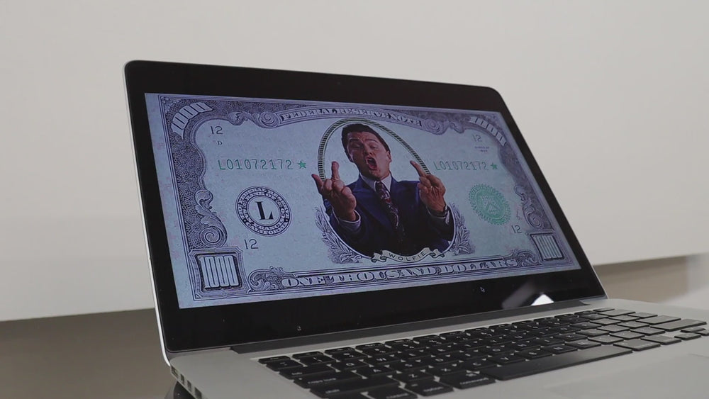 Large-scale string and nail artwork depicting a stylised one-thousand-dollar bill featuring the Wolf of Wall Street figure at its centre, captured mid-shout with raised middle fingers, intricately crafted in monochrome thread with fine detailing.